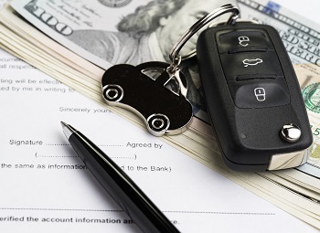 set of car keys on top of a stack of cash