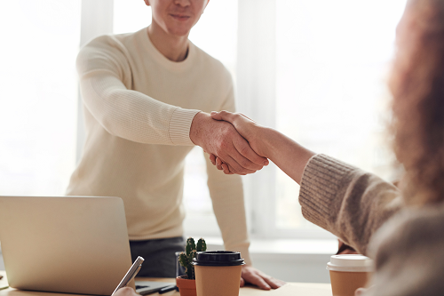 a person shaking hands with another person at a business setting