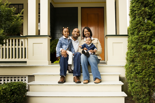 family sitting on house steps