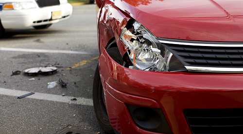 a crashed red car on the side of a road